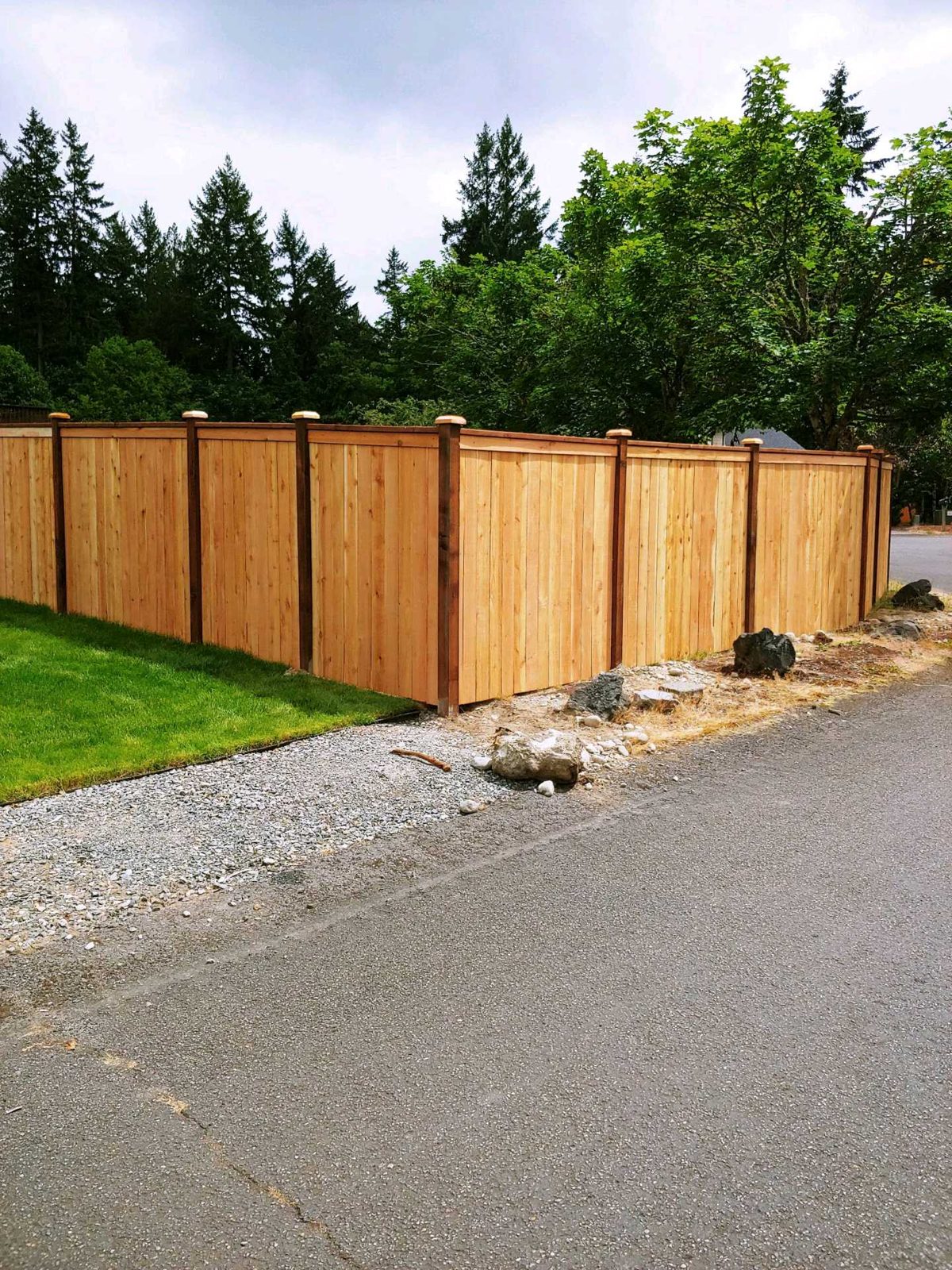 Cedar privacy fence at a gravel corner